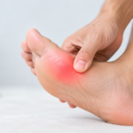 Person holding a painful big toe during a hallux rigidus flare-up